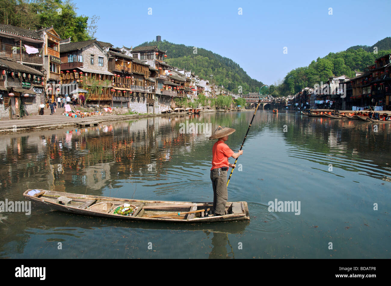 Homme debout et padling voile Tuo River ancienne ville de Fenghuang Chine Hunan Banque D'Images