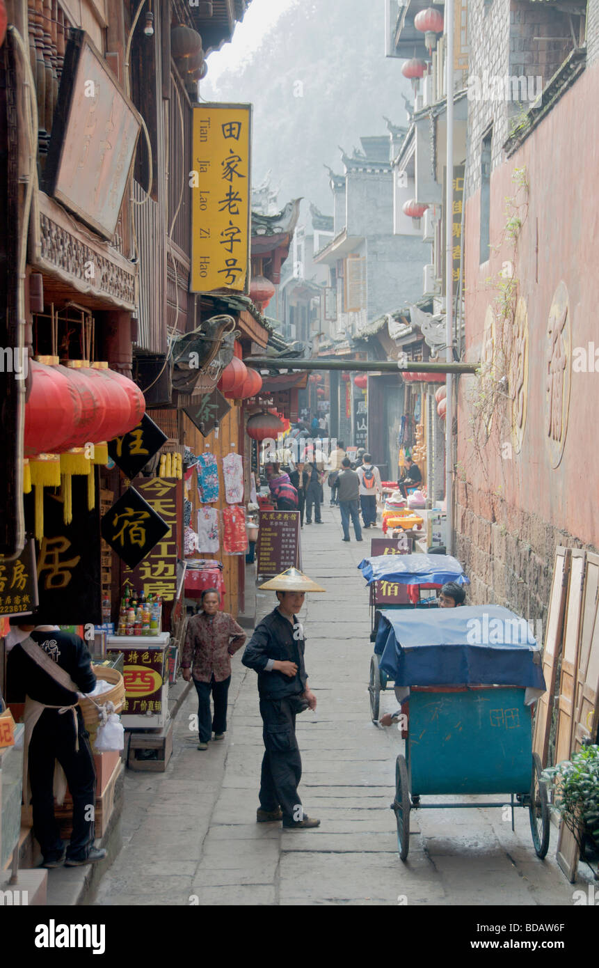 Rickshaw et boutiques rue arrière étroit ancienne ville de Fenghuang Chine Hunan Banque D'Images