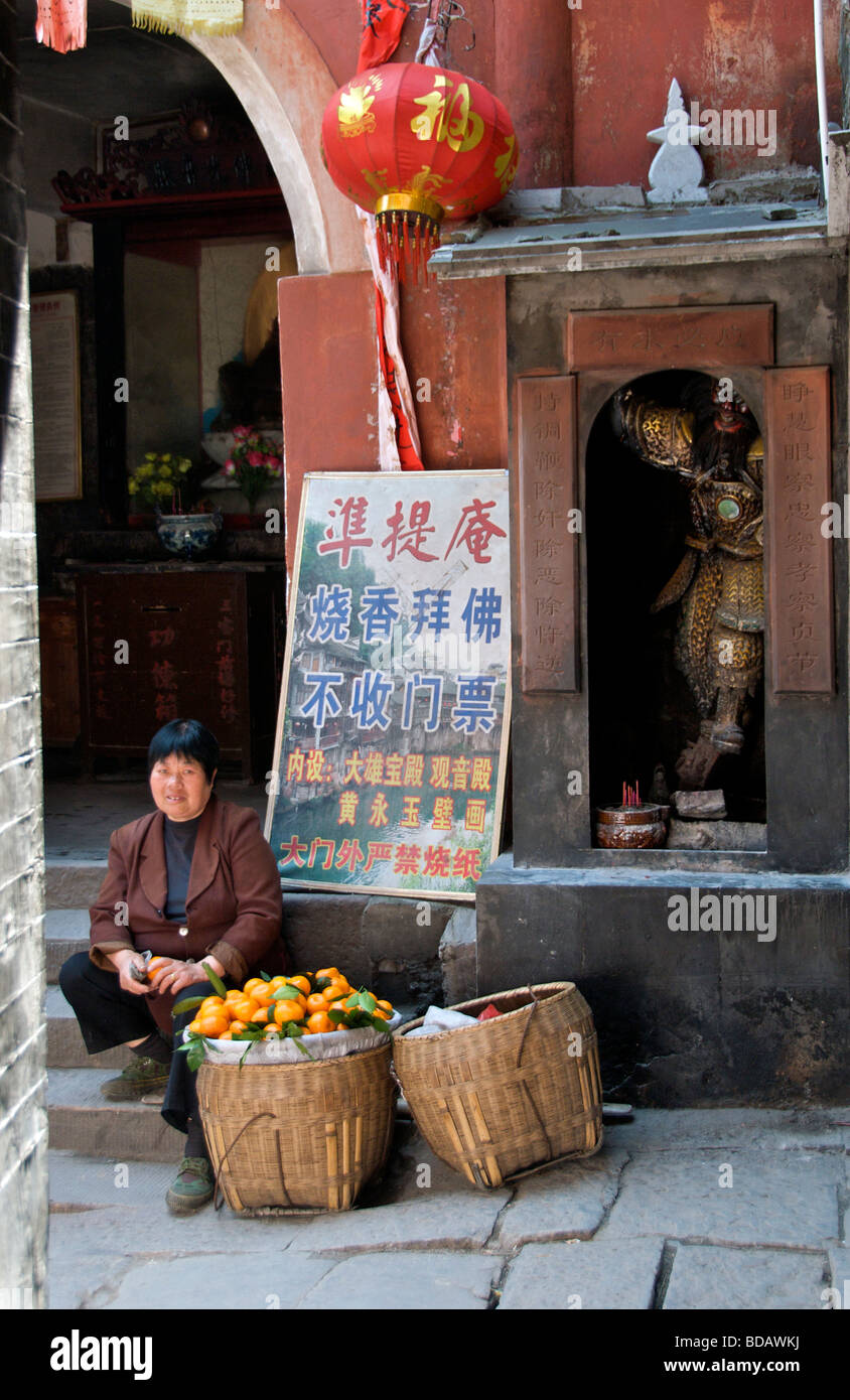 Femme vendant des oranges dans la ruelle ancienne ville de Fenghuang Chine Hunan Banque D'Images