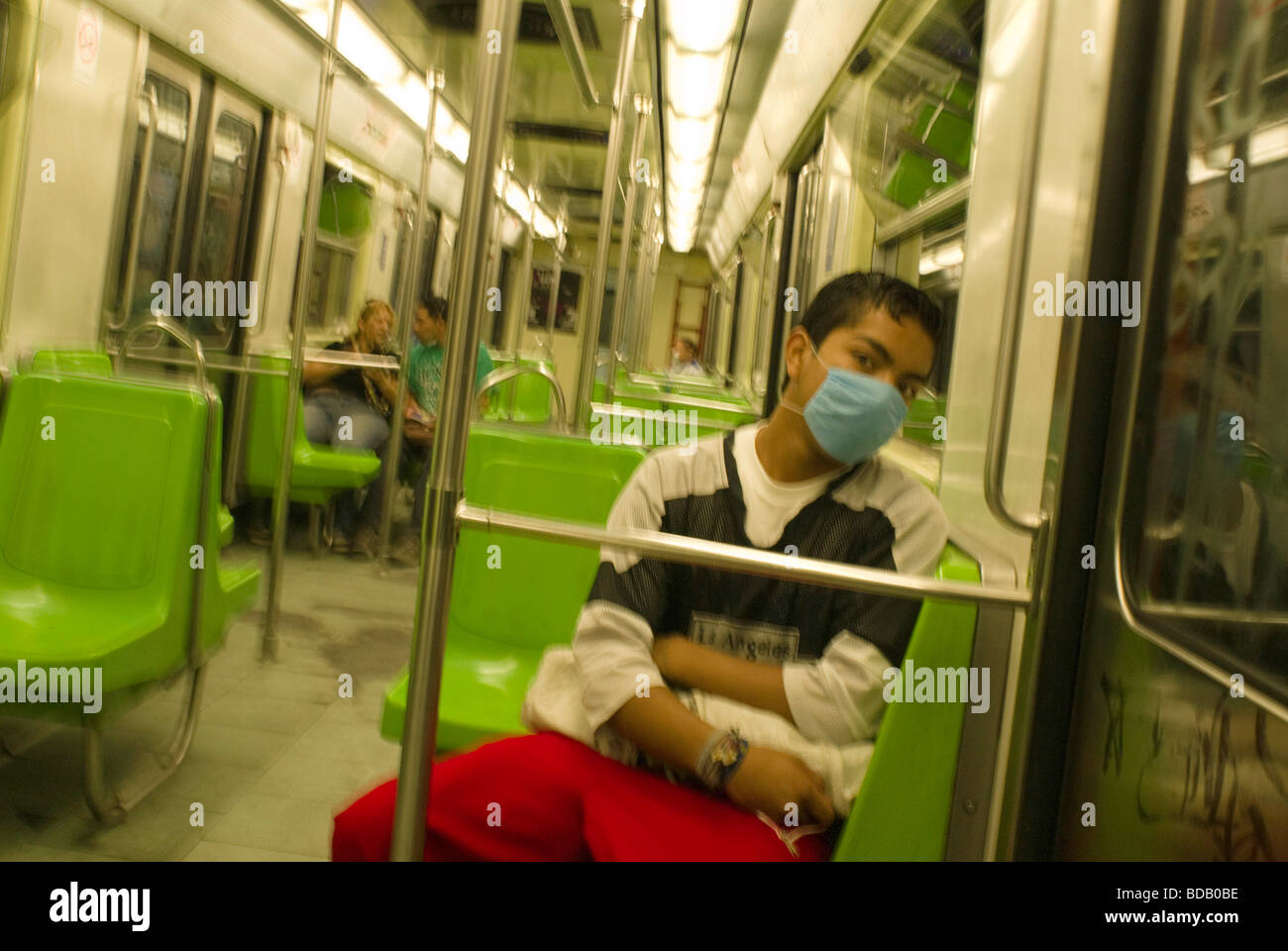 Un jeune homme porte un masque chirurgical sur le métro de Mexico au cours d'une épidémie de grippe porcine. Banque D'Images