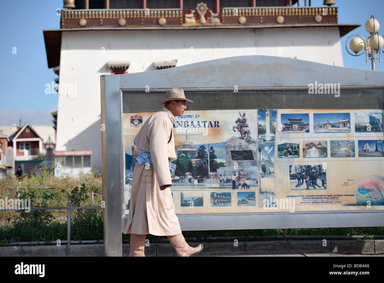 Bien-habillés cowboy mongole de géant passé un 'Bienvenue à Oulan-bator' signe, Oulan-Bator, Mongolie Banque D'Images