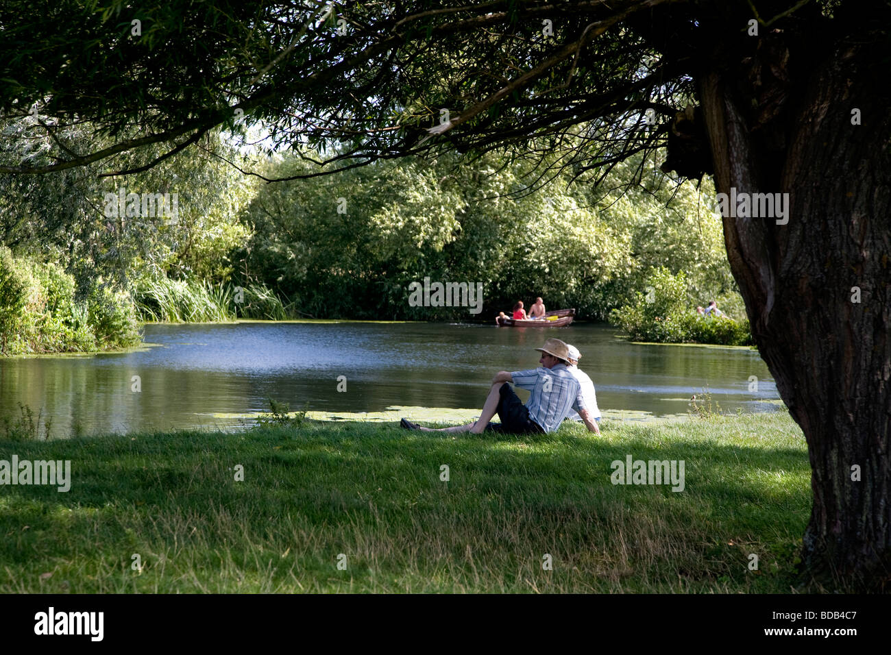 Les gens de bateau sur la rivière Stour avec un homme qui regarde, entre le village historique de Dedham et dans le pays de Constable Flatford Banque D'Images