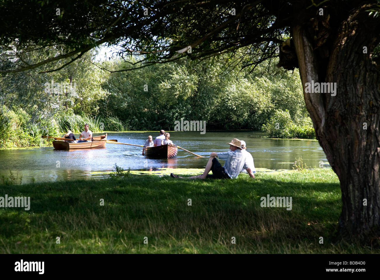 Les gens de bateau sur la rivière Stour avec un homme qui regarde, entre le village historique de Dedham et dans le pays de Constable Flatford Banque D'Images