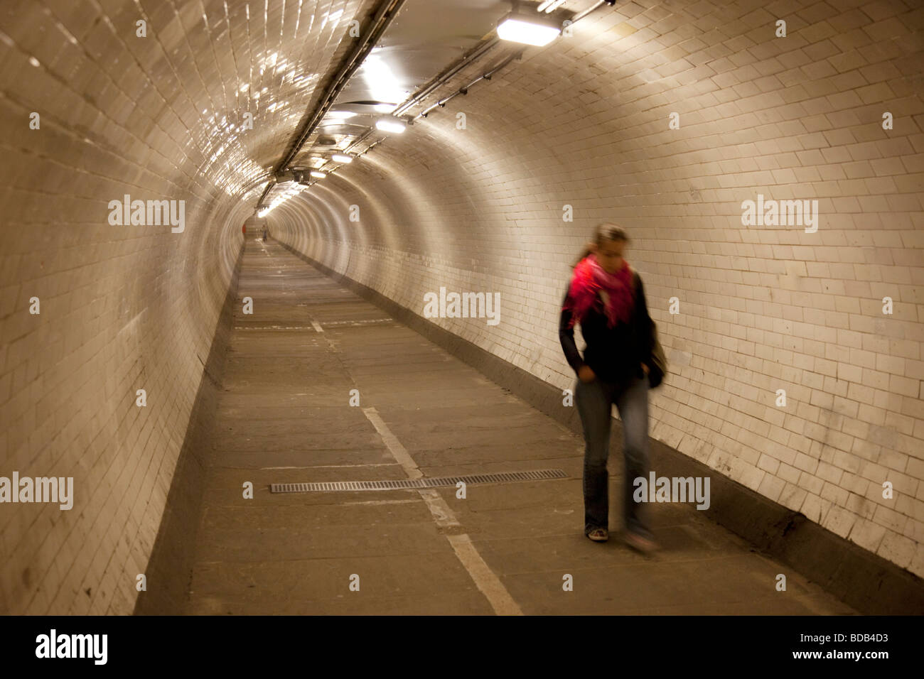 Femme marche sur le pied de Greenwich tunnel qui relie l'Isle of Dogs avec Greenwich dans le sud-est de Londres. Banque D'Images