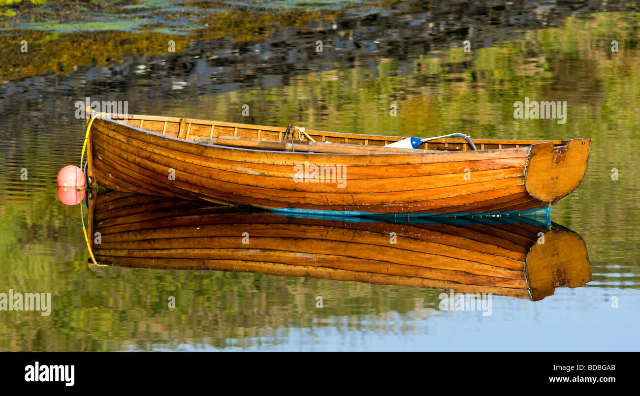 Bateau à rames et sa réflexion mouillée dans une petite baie de Loch Leven, Ecosse Banque D'Images