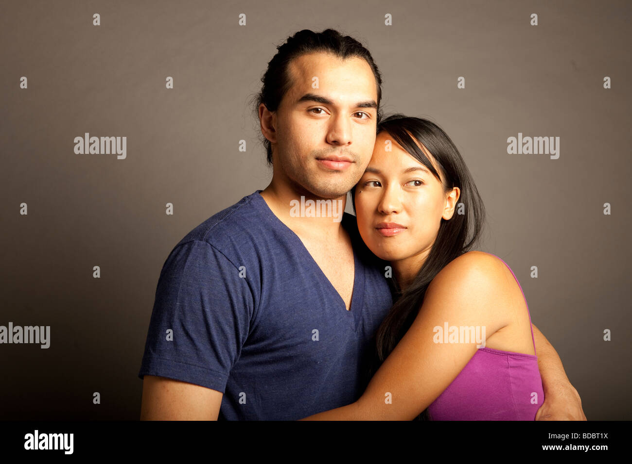 Portrait de femmes et hommes philippins ethniques couple contre fond gris. En regardant la caméra. Banque D'Images