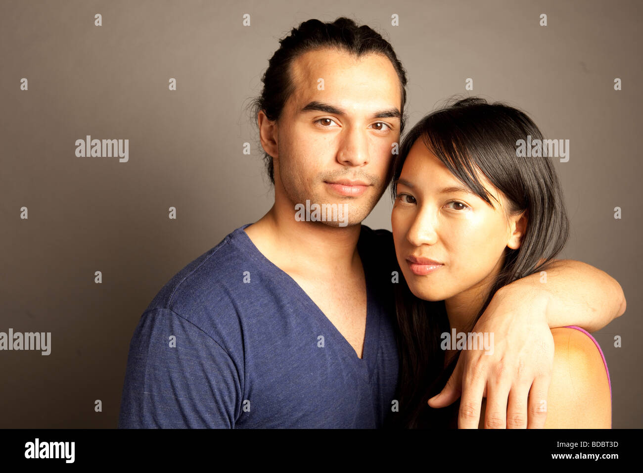 Portrait de femmes et hommes philippins ethniques couple contre fond gris. En regardant la caméra. Banque D'Images