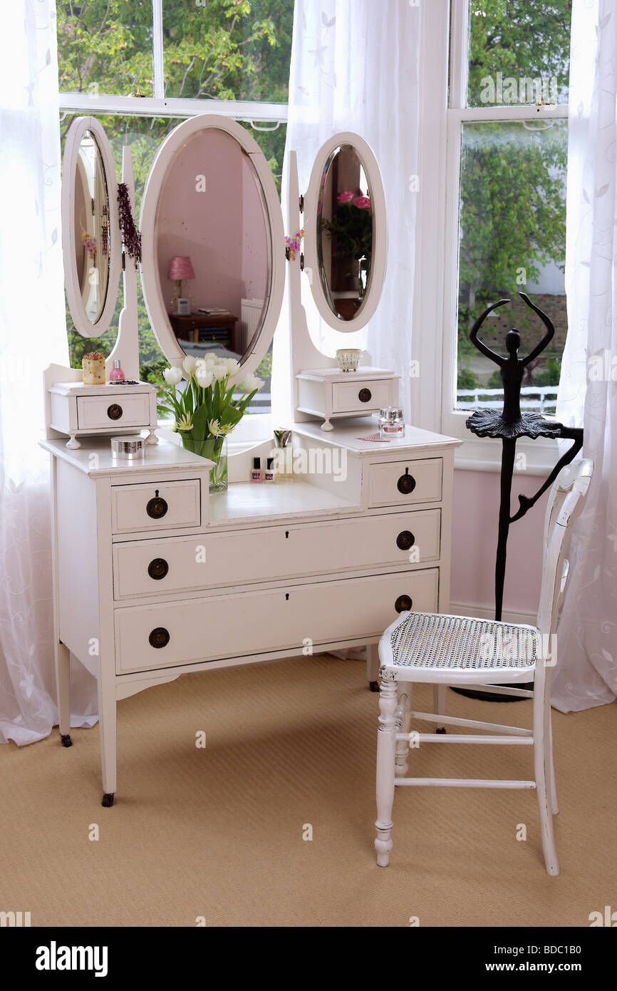 White coiffeuse avec miroir triple et chaise blanche en face de la fenêtre  de la chambre Photo Stock - Alamy