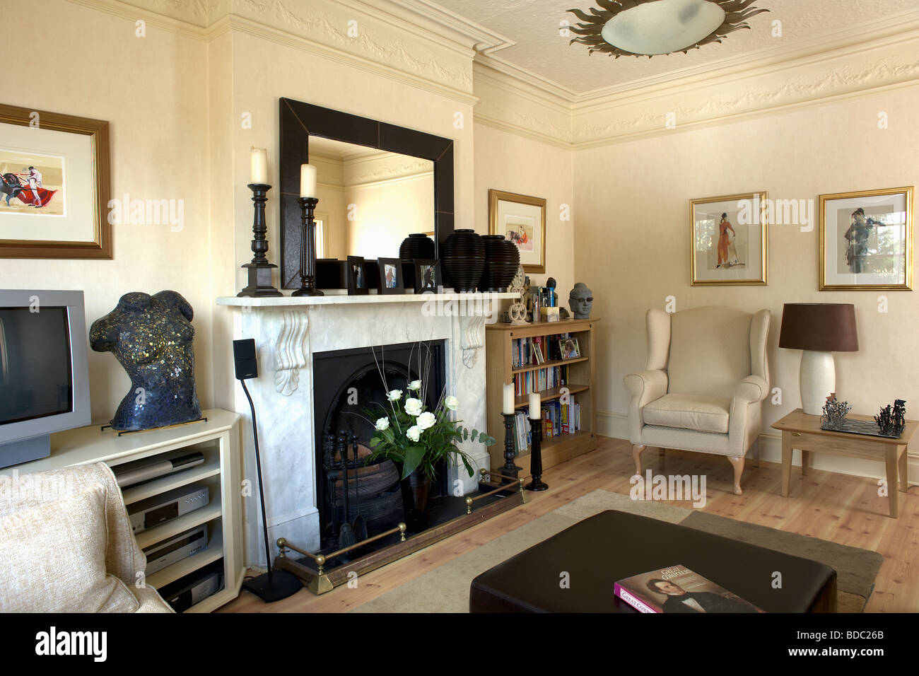 Miroir sur la cheminée de marbre dans la crème traditionnel salon avec fauteuil crème Banque D'Images