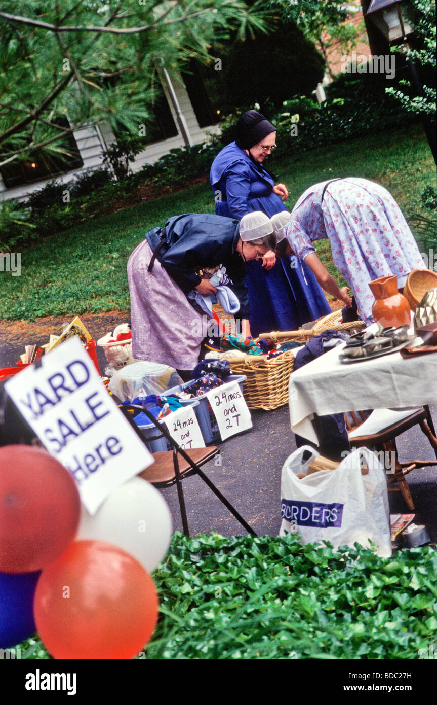 Groupe de jeunes et vieilles femmes amish recherche d'affaires dans la banlieue de maison familiale, garage vente-débarras. Banque D'Images