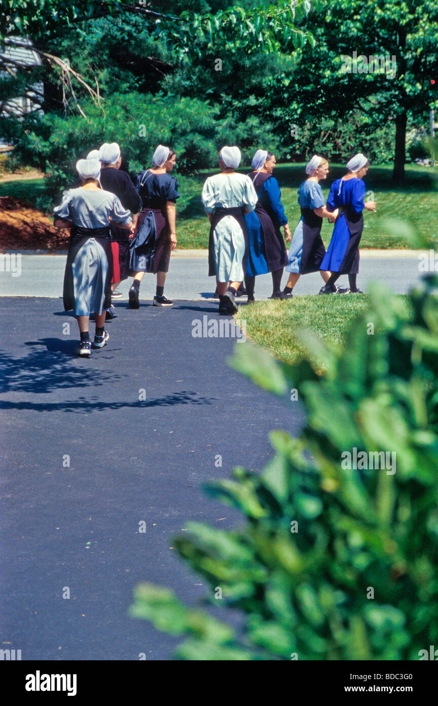 Groupe de jeunes femmes amish laisser le chemin de la maison familiale de banlieue, garage vente-débarras. Banque D'Images