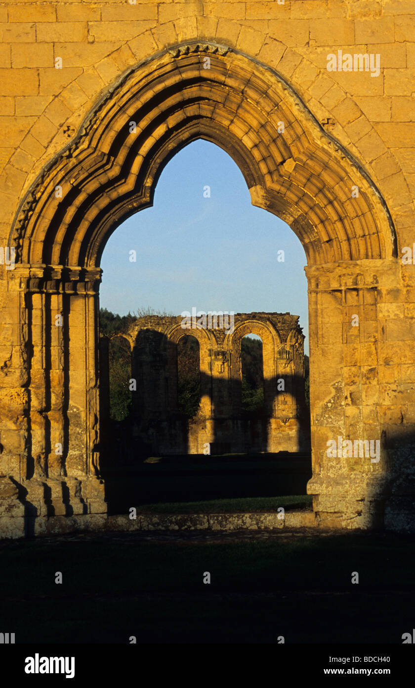 Soleil de fin de soirée sur le 12ème siècle. La porte ouest de la ruiné Byland Abbey, dans le hameau de Byland Abbey, Yorkshire, Angleterre Banque D'Images