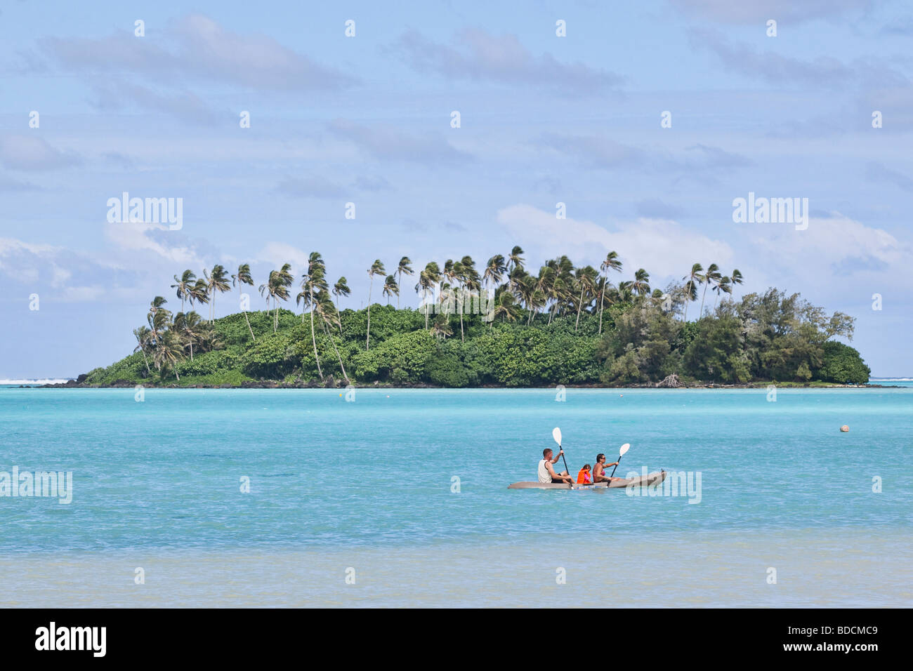 Un kayak en passant par une île tropicale à l'horizon comme vu de Muri Beach de Rarotonga aux îles Cook dans le Pacifique Banque D'Images