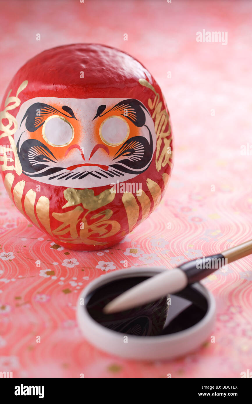 Daruma doll et pinceau de calligraphie Banque D'Images