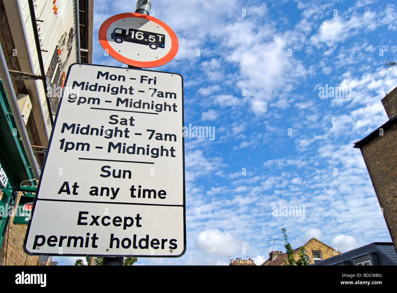 Panneau routier britannique montrant des interdictions de stationnement et limite de poids du véhicule, sous les nuages en cirrocumulous East Sheen, le sud-ouest de Londres, Angleterre Banque D'Images