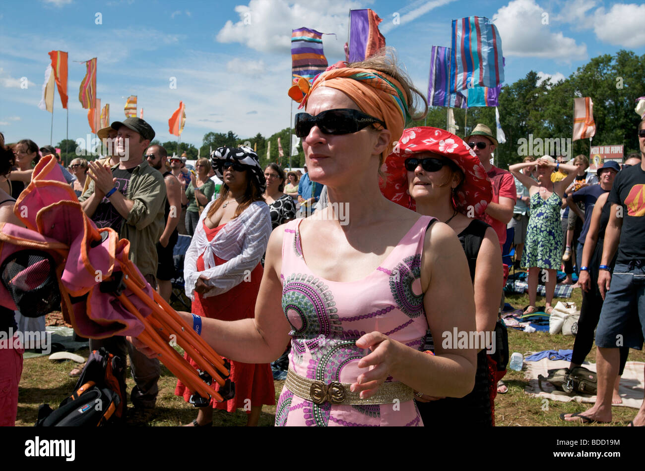 Une femme portant des vêtements festival festival entouré de spectateurs vêtus de vêtements hippie vous apprécierez le spectacle au festival de musique WOMAD Banque D'Images