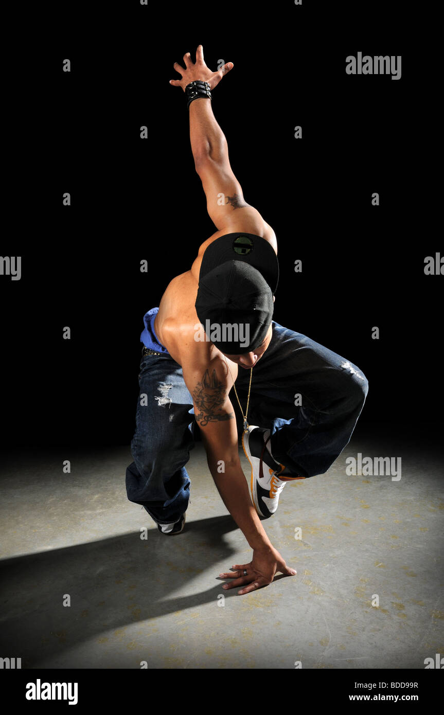 African American hip hop dancer performing sur fond sombre Banque D'Images