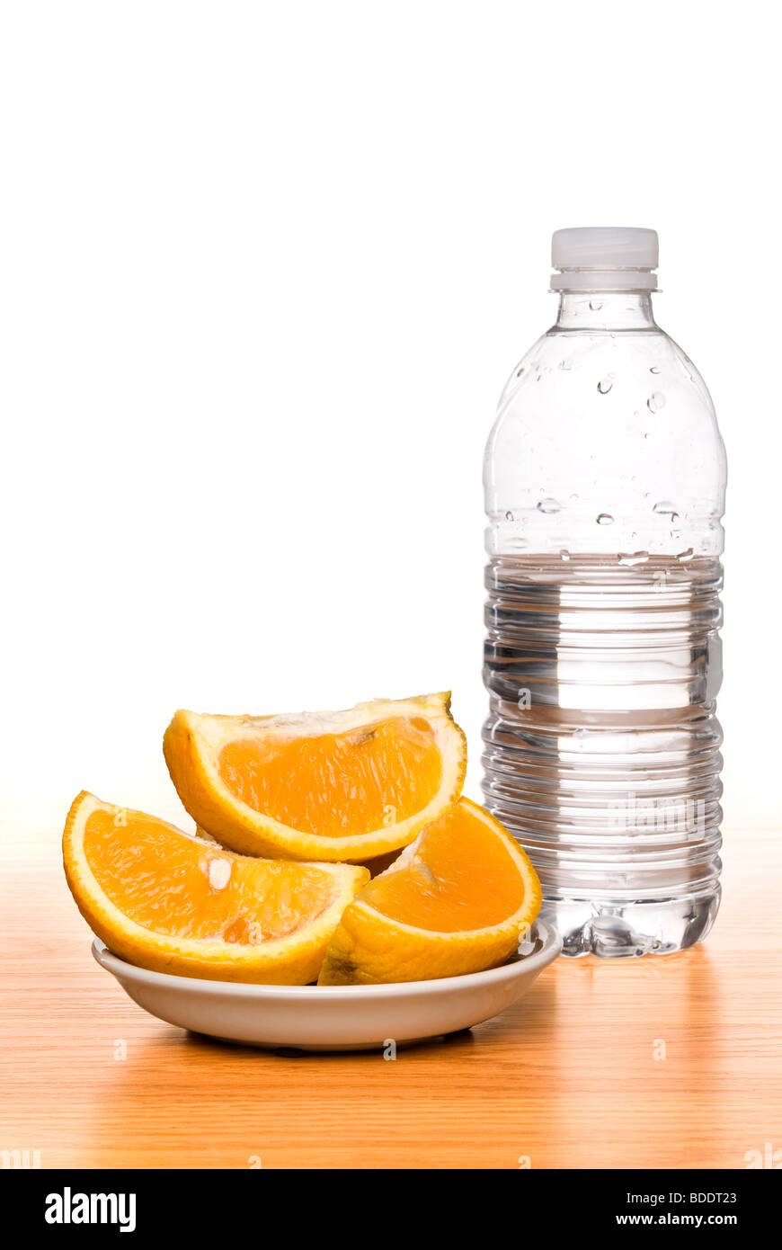 Une image conceptuelle pour la saine alimentation et de l'amaigrissement, montrant une bouteille d'eau fraîche et douce, les oranges mûres. Banque D'Images