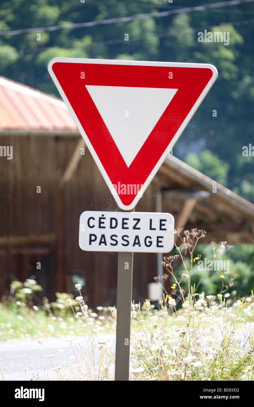 Le Français moyen donner ou Cedez le passage signe à la jonction de route Banque D'Images