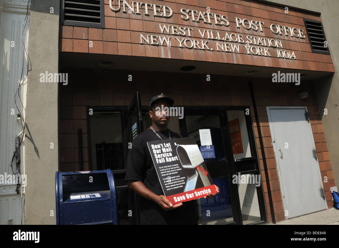 Un travailleur des services postaux à Greenwich Village proteste contre la possible fermeture de 14 bureaux de poste dans la ville de New York. Banque D'Images
