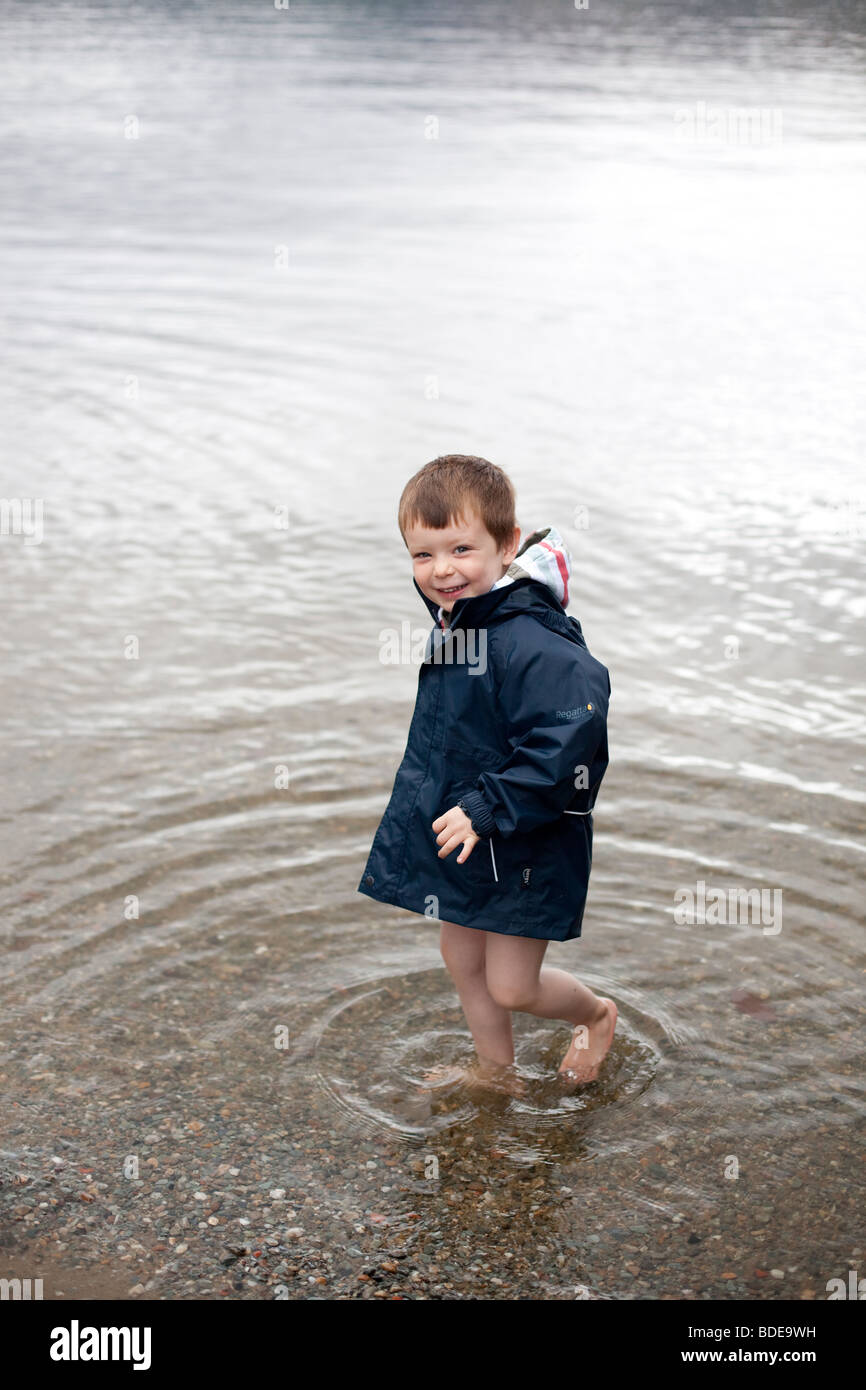 Un garçon de quatre ans portant une veste imperméable palettes dans le Loch  Lomond, Ecosse Photo Stock - Alamy