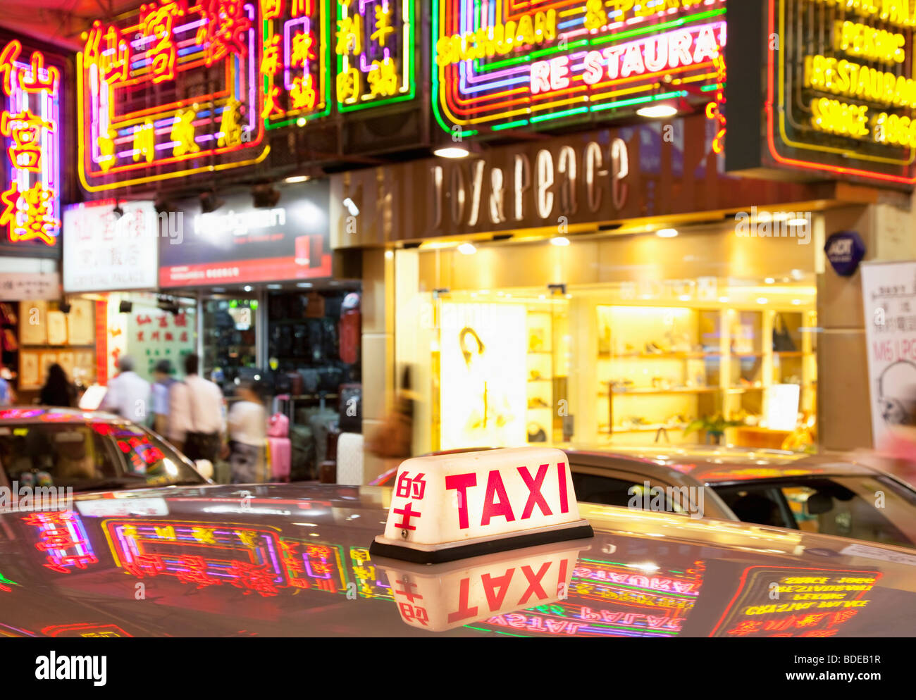 Enseignes au néon et lumière de taxi à Tsim Sha Tsui, Kowloon, Hong Kong, Chine. Banque D'Images