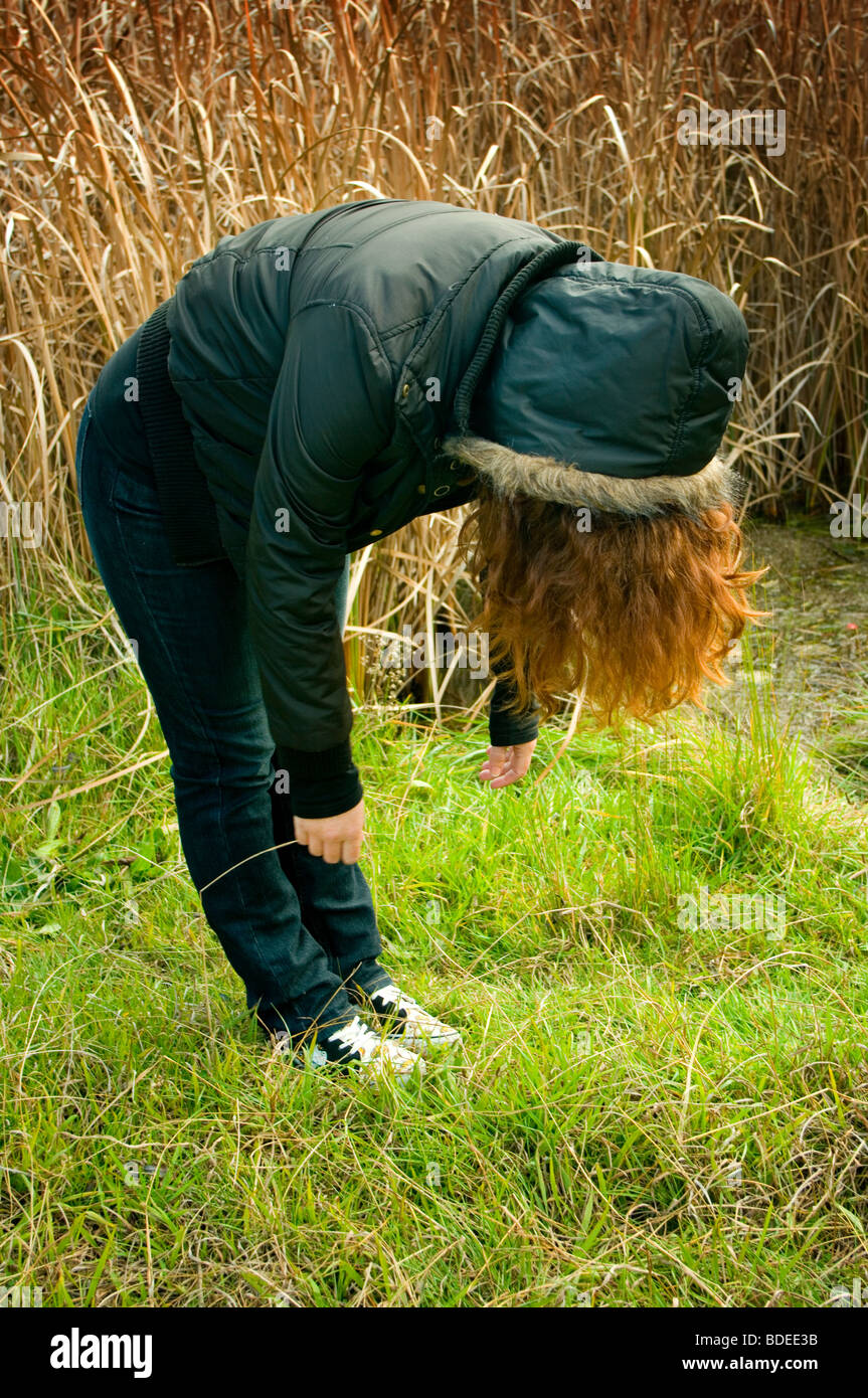 Une femme aux cheveux rouges par un lac d'hiver. Banque D'Images