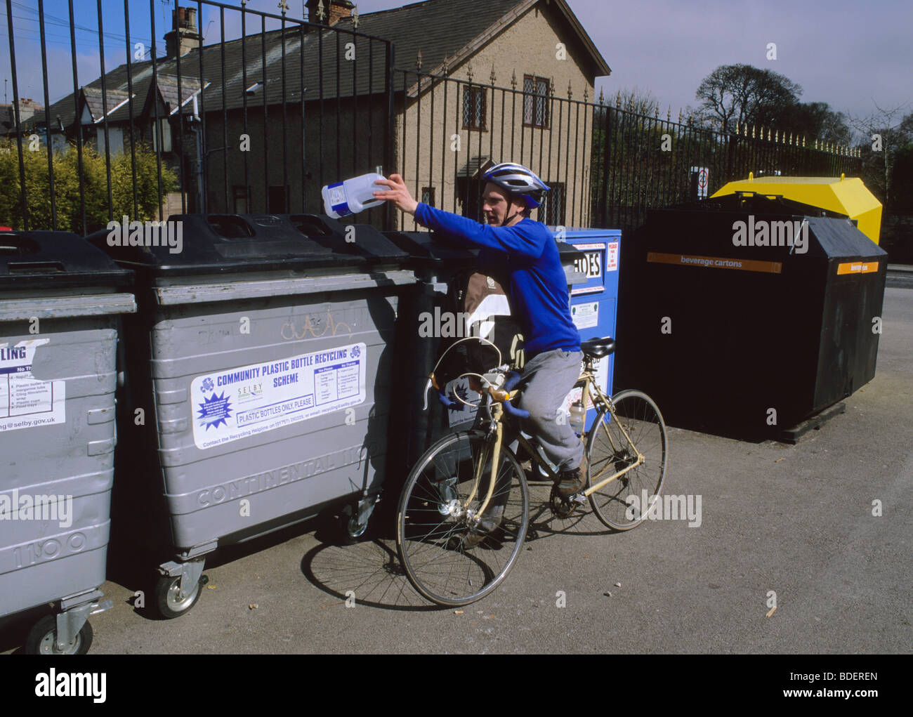 L'homme en vélo avec un sac plein de bouteilles pour le recyclage au point de recyclage Leeds Yorkshire UK Banque D'Images