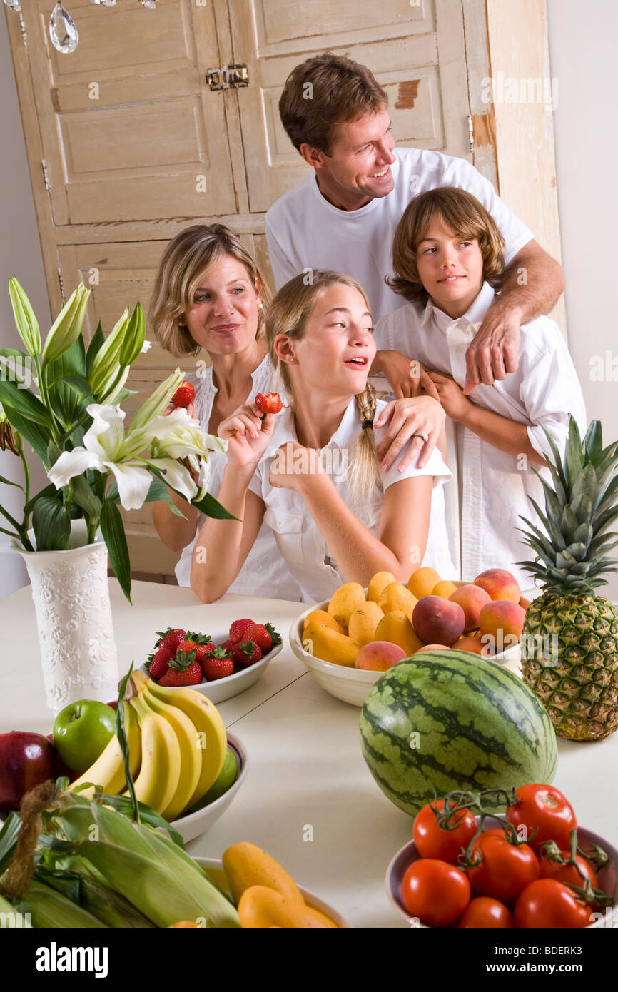 Jeune famille dans la salle à manger des fruits et légumes Banque D'Images