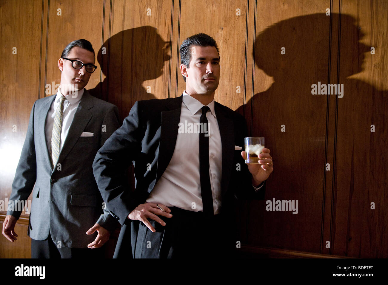 Vintage portrait de hommes d'appuyé contre un mur lambrissé en salle Banque D'Images