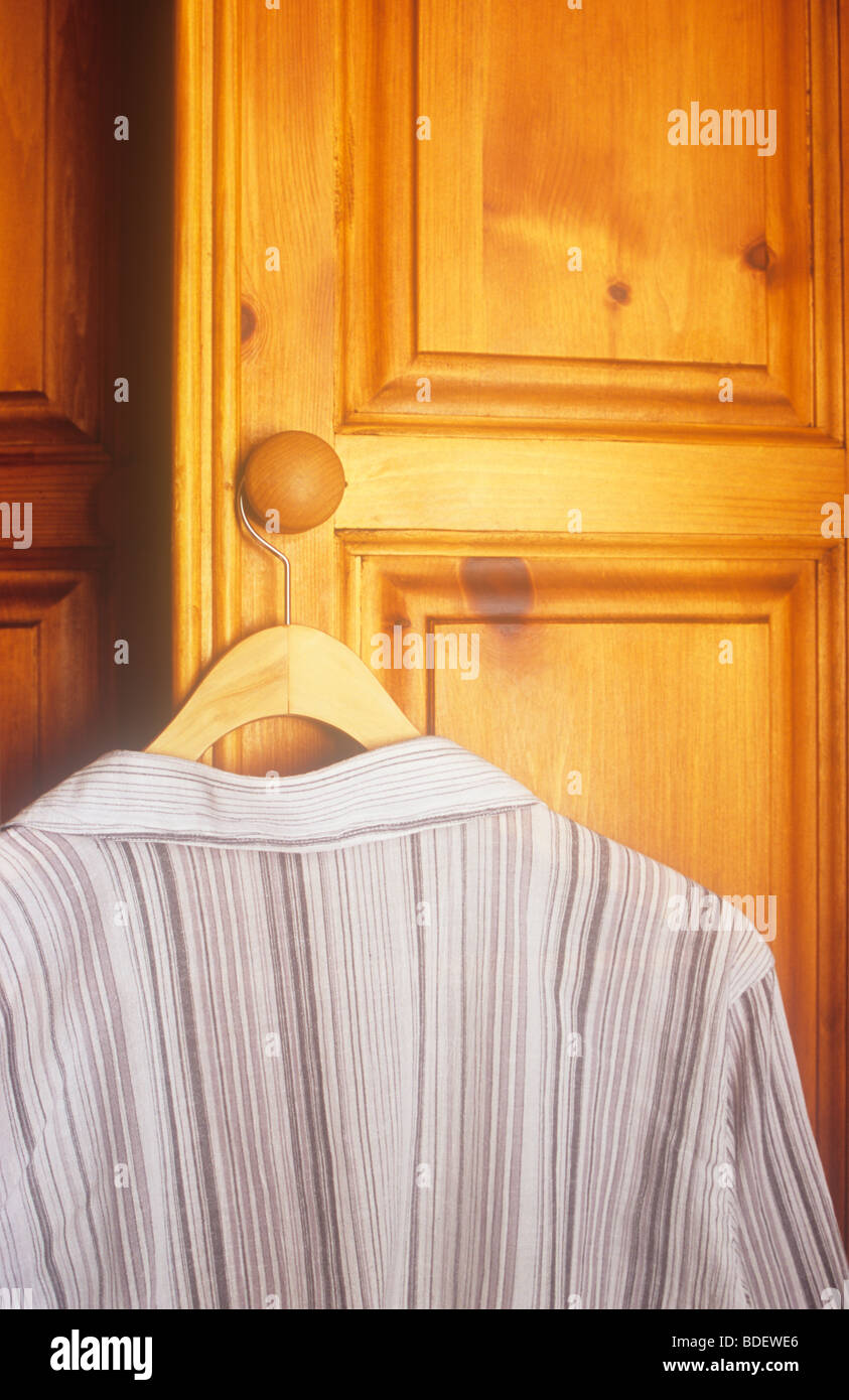 Chemise rayée gris et blanc ou chemisier sur cintre en bois poignée bois de pin de l'armoire Banque D'Images