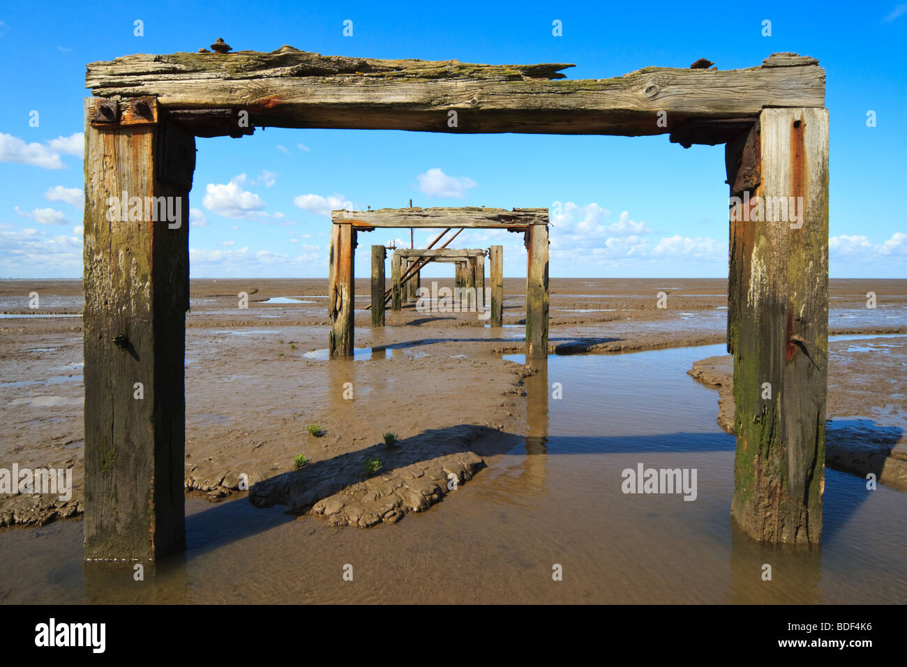 Vue de l'estuaire de lavage par l'intermédiaire de supports en bois d'une ancienne jetée, King's Lynn, Norfolk, England, UK Banque D'Images