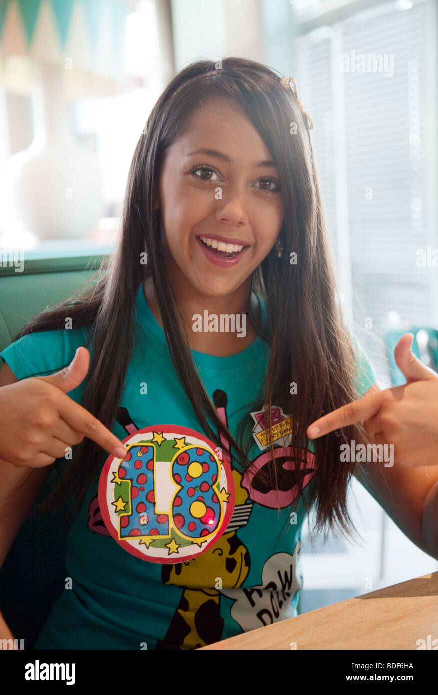 Une jeune fille profitant de son 18e anniversaire soulignant son anniversaire badge et smiling Banque D'Images