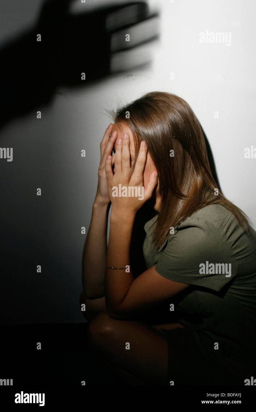 La violence domestique. Femme sous ombre de part sur le point de la frapper. Posée par pic modèle. Banque D'Images