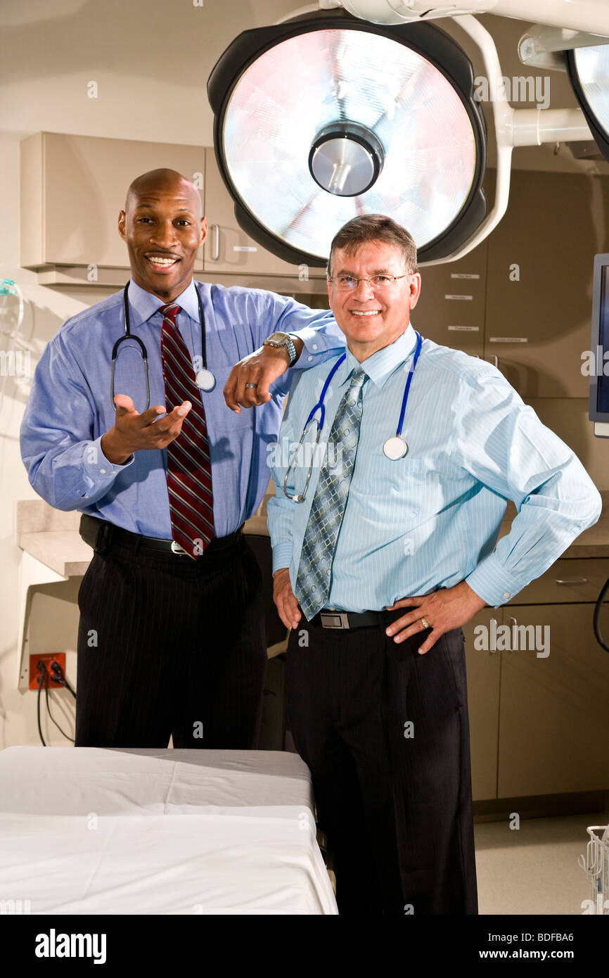 Les médecins en multi-ethnique chambre d'hôpital avec feux chirurgicale Banque D'Images