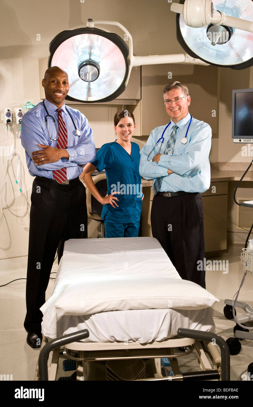 Les médecins en multi-ethnique chambre d'hôpital avec feux chirurgicale Banque D'Images