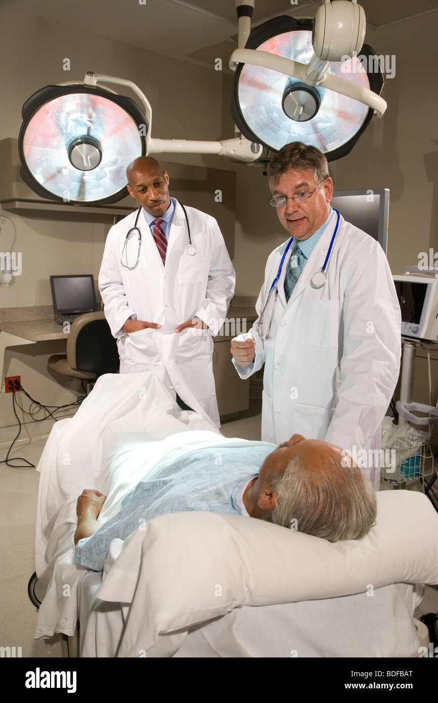 Doctors talking with patient in hospital room Banque D'Images