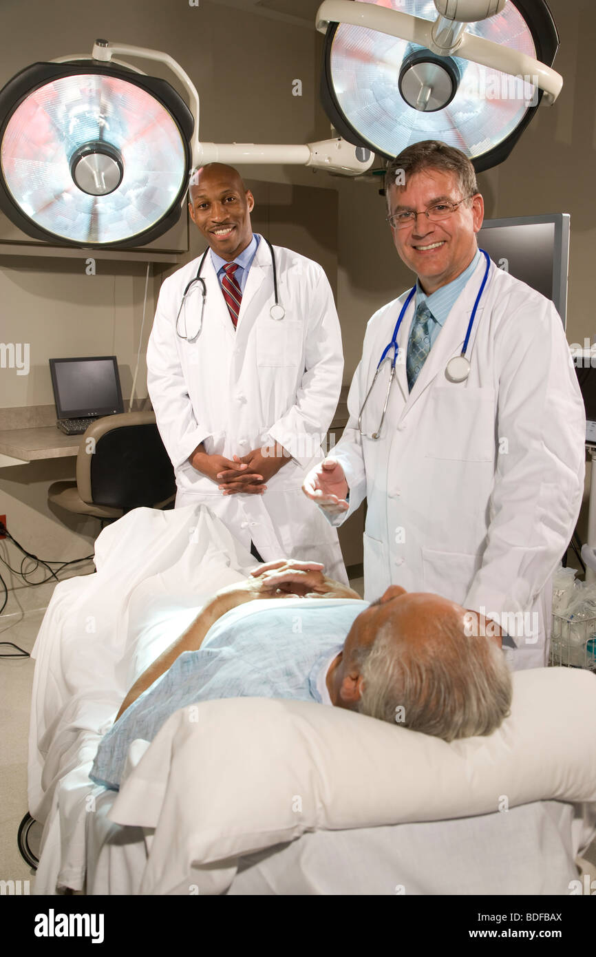 Doctors talking with patient in hospital room Banque D'Images