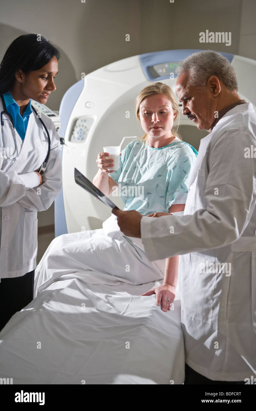 Les médecins l'examen CT scan results with patient Banque D'Images