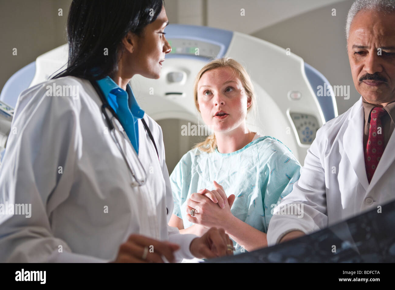 Les médecins l'examen CT scan results with patient Banque D'Images
