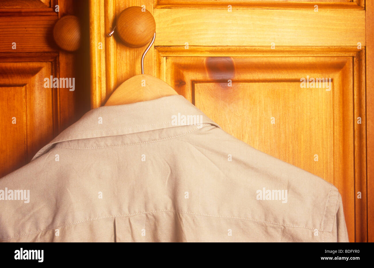 Brun pâle chemise sur cintre en bois poignée bois de pin de l'armoire Banque D'Images
