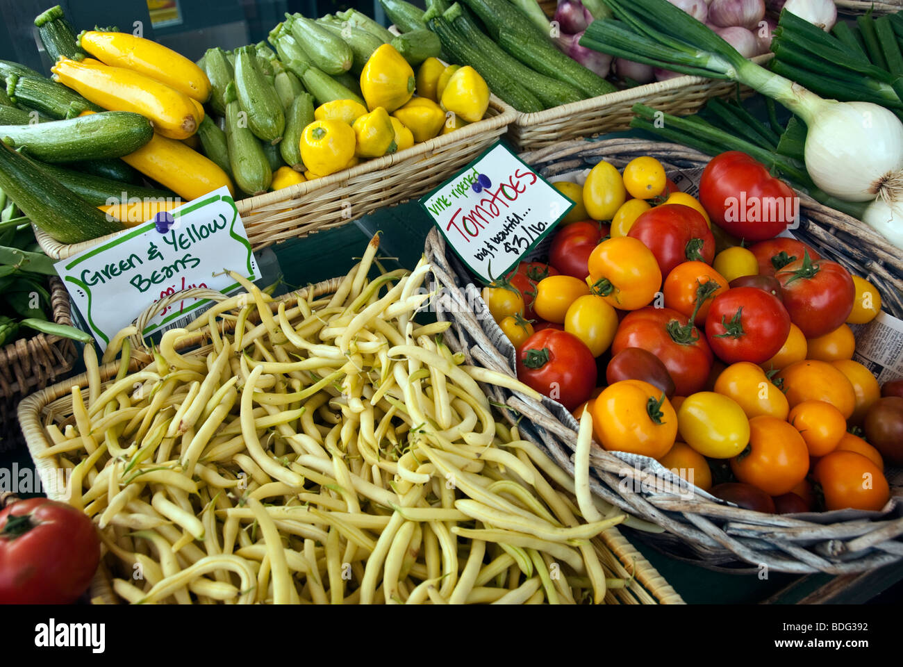 Les paniers en osier avec une variété de tomates fraîches, squash et des haricots jaunes exposés à la vente au marché vert Bellingham Banque D'Images