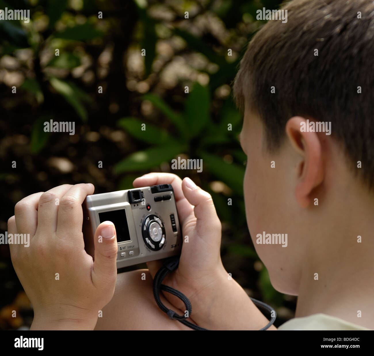 Jeune garçon anglais à l'aide d'un appareil photo numérique. Banque D'Images