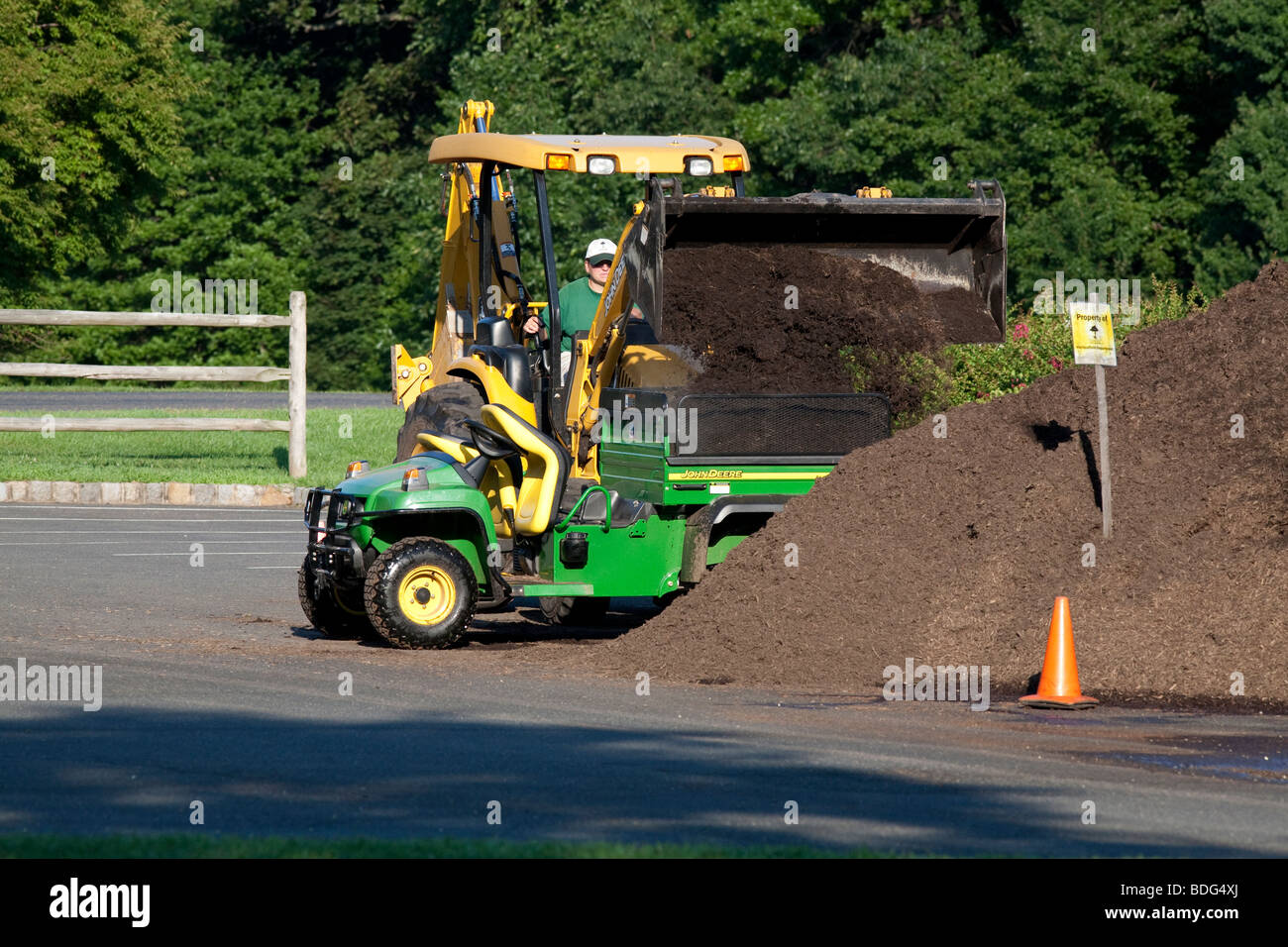 Déménagement mulch avec un tracteur John Deere et véhicule utilitaire. Banque D'Images