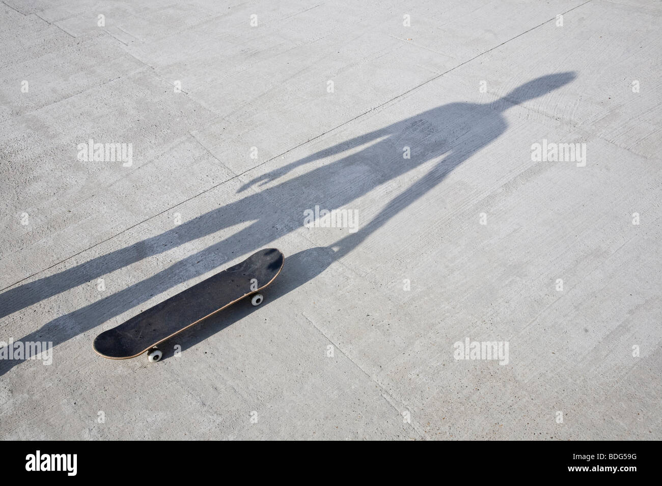 Ombre tenant un skateboard Banque D'Images