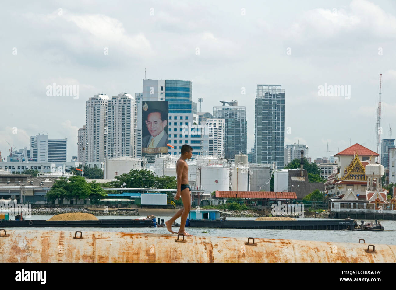 Garçon sur un pétrolier en face de la Thai le roi Bhumibol vu de l'autre côté de la rivière Chao Phraya à Bangkok Banque D'Images