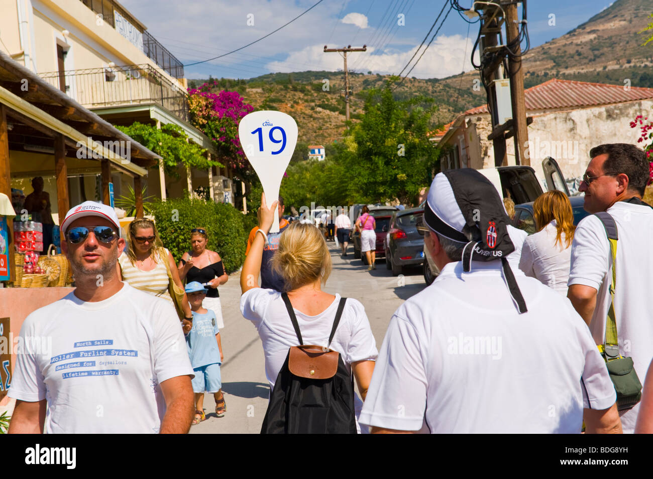 Visite organisée avec groupe guide 19 marche à travers le village d'Assos sur Méditerranée grec île de Céphalonie, Grèce GR Banque D'Images