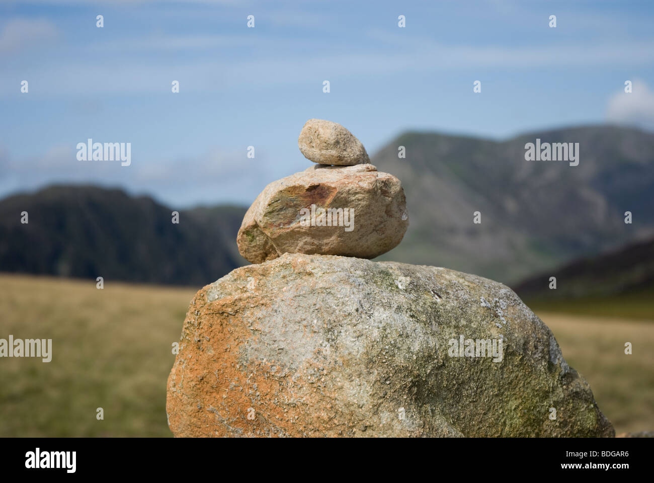 Gros plan de roches empilées sur un cairn sur Grey knotts, dans le Lake District Fells, Cumbria. Avec Haystacks et High Crag en arrière-plan Banque D'Images