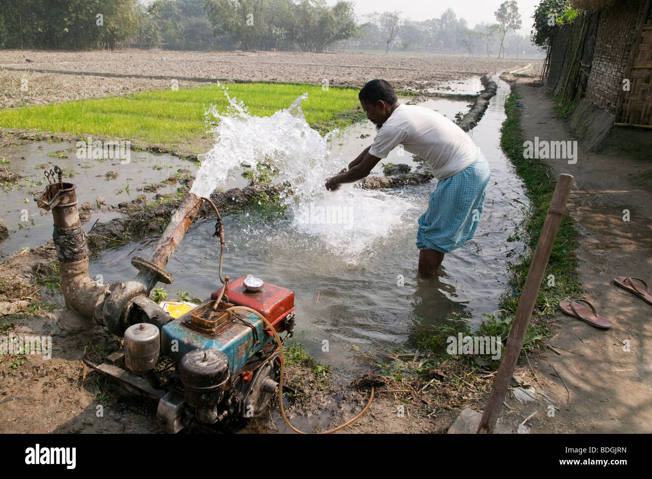 L'homme se laver les mains à la pompe à eau motorisé Bangladesh Banque D'Images