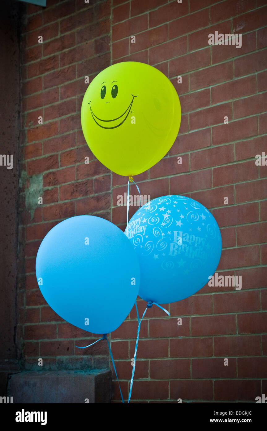 Visage souriant jaune marque ballons bleu entrée de la partie. Banque D'Images